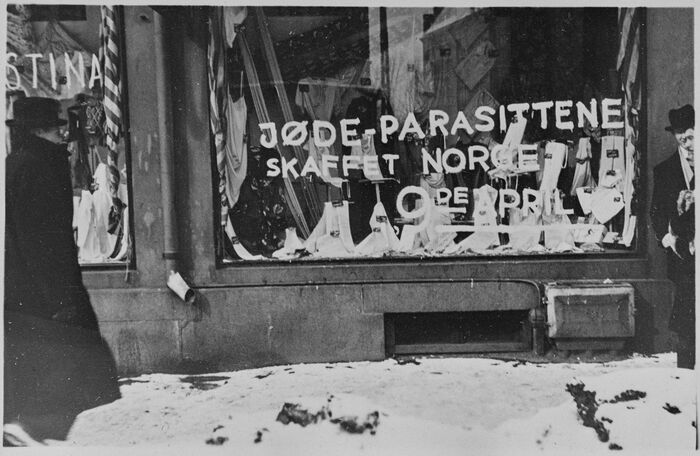Butikkvindu med tagging på glassruten: "Jødeparasittene skaffet Norge 9. april"