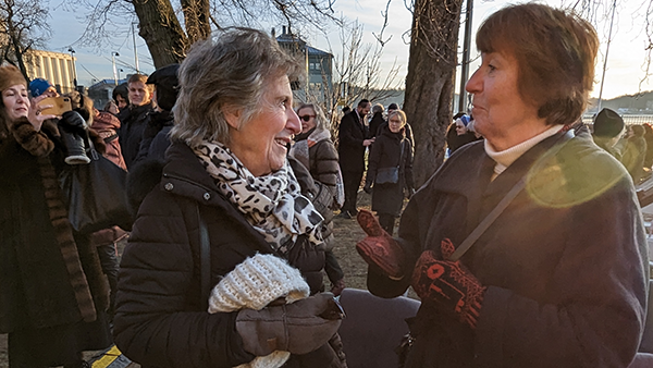 Nærbilde av to godt voksne kvinner som hilser på hverandre i en stor folkemengde,