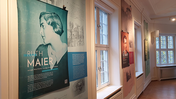 Plakat med portrett av en kvinne og teksten "Ruth Maier", i et rom med to vinduer