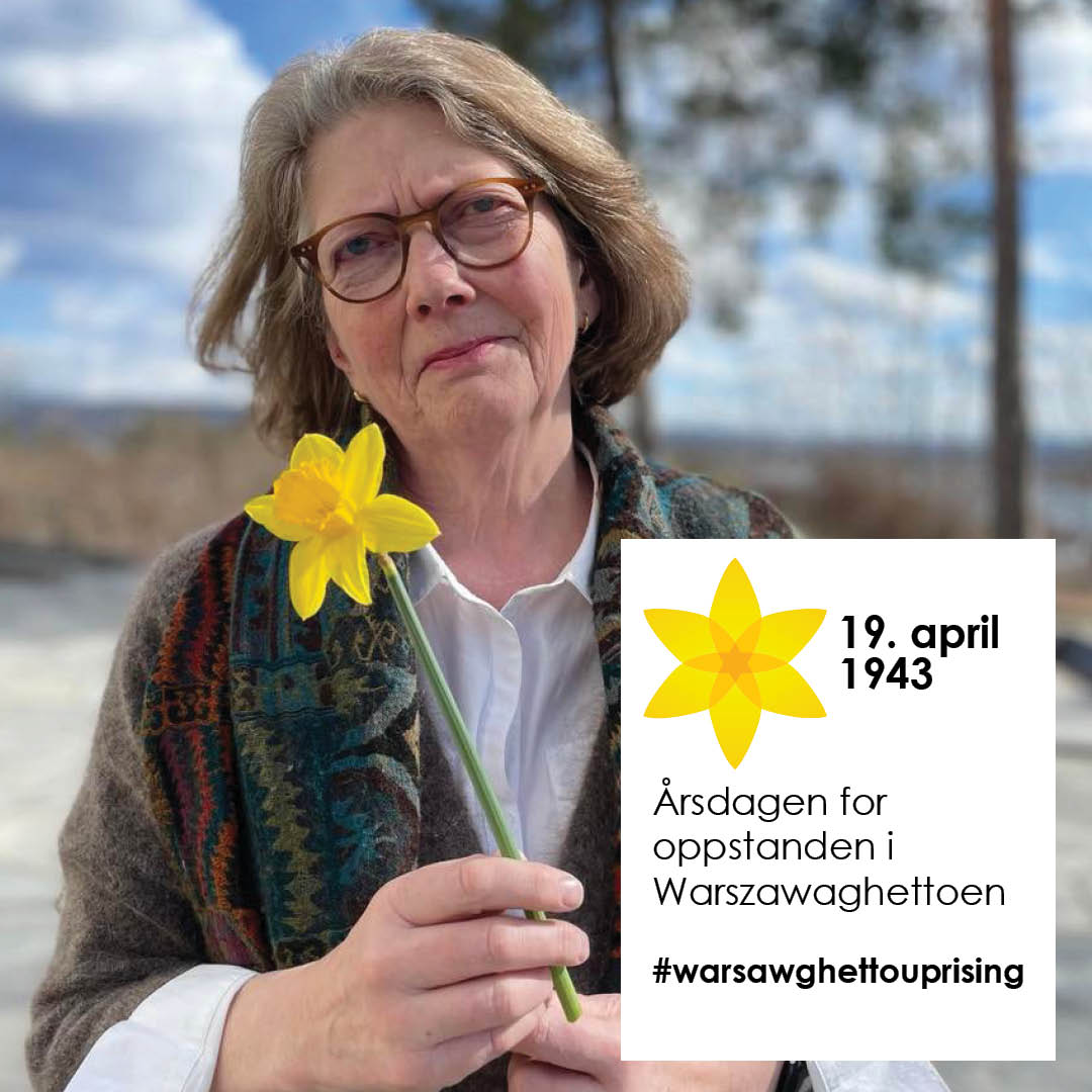 Guri Hjeltnes med gul påskelilje og en plakat med teksten "19. april 1943. Årsdagen for oppstanden i Warszawaghettoen