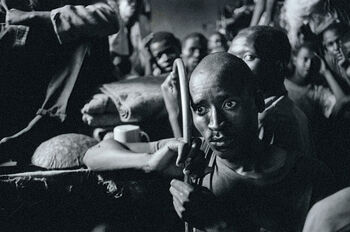 Sort-hvitt bilde som viser en afrikansk mann med store øyne. Mannen ser redd og trist ut.