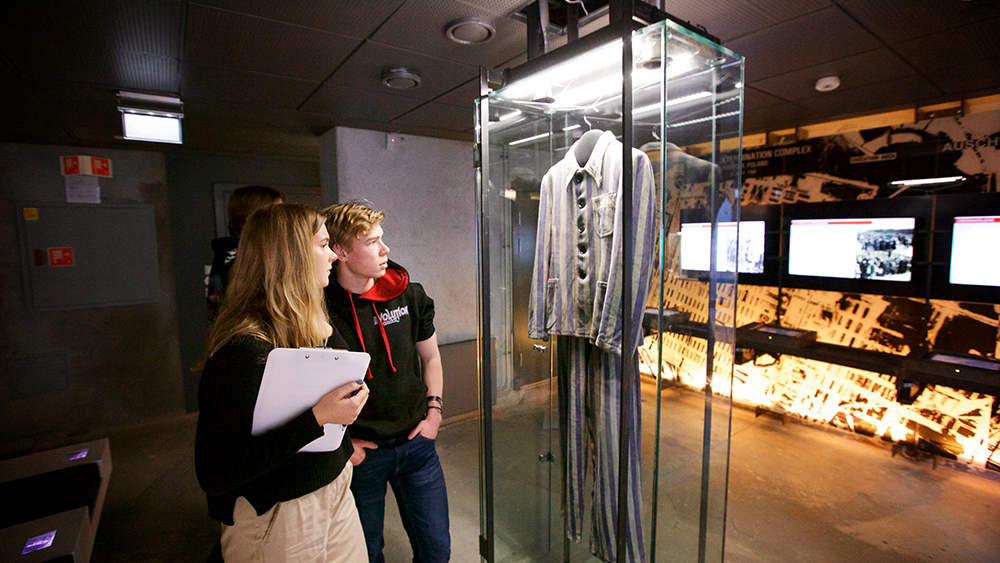 Two young people studying a prisoner suit.